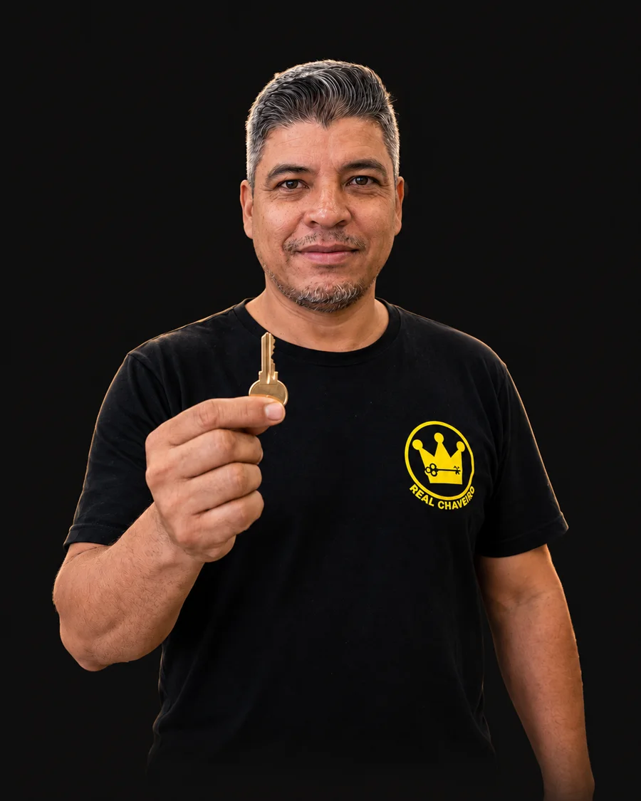 Cleber, do Real Chaveiro, segurando uma chave, de camiseta preta com o logo