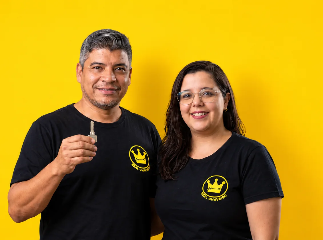 Cleber, segurando uma chave, e Thatiany, os donos do Real Chaveiro, de camiseta preta com o logo